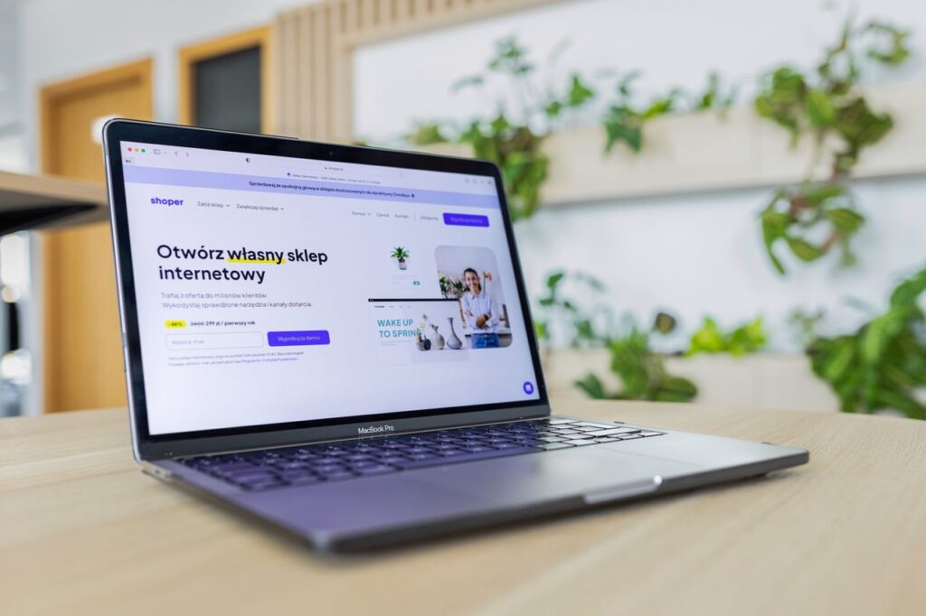 Close-up of a laptop with an open e-commerce website, surrounded by modern office decor.